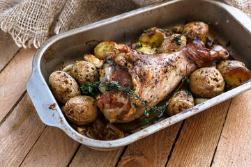 Oven baked turkey leg with potato and spices, rustic style, top view