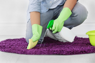 Man cleaning small rug indoors