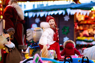 Child on Christmas fair. Kid riding Xmas carousel