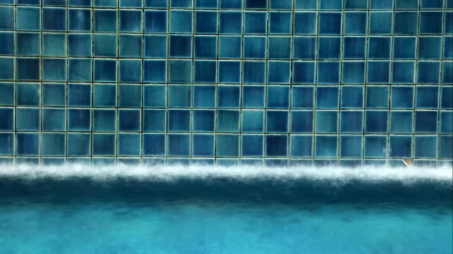 Accelerated movie from swimming pool with running water on the wall of the tile