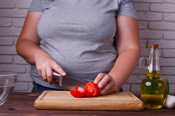 Dieting, healthy low calorie food, weight losing concept. Overweight woman chopping tomato, cooking salad close up