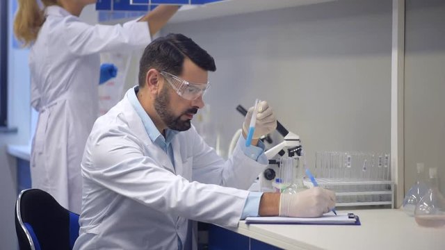 Male scientist carrying out chemical experiment in laboratory