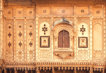 Closed window of an old house with carvings on walls. Indian tradition of architecture