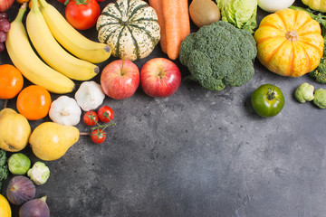 Above view of different rainbow vegetables and fruits on the light grey background, copy space for text below, selective focus