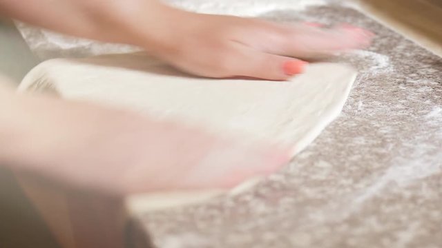 Professional italian baker kneading dough by hands on table. The process of cooking pizza by a cook in a restaurant.
