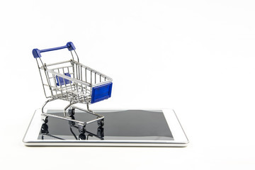 shopping cart with tablet on white backgrond , Means shopping online