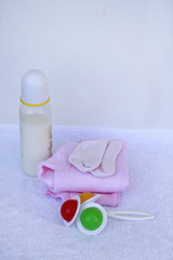 Set for newborn girl with baby milk, toy, little socks and clothes on white background.
