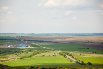 Green meadow under blue sky with clouds Green field bright green young grass wheat barley spring field shoots on the field young grass