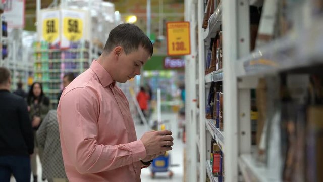 young guy buys coffee beans in a store or supermarket.