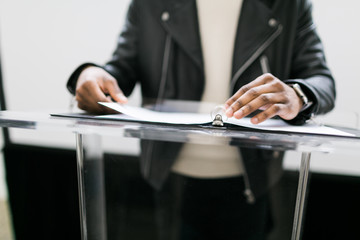 Young man with a ring binder on a podium