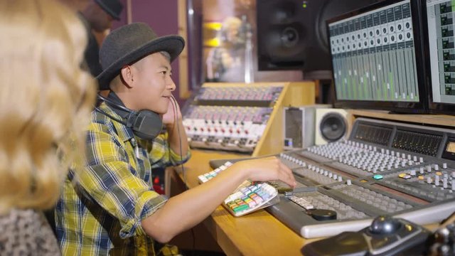  Professional team in recording studio mixing a track with female vocalist