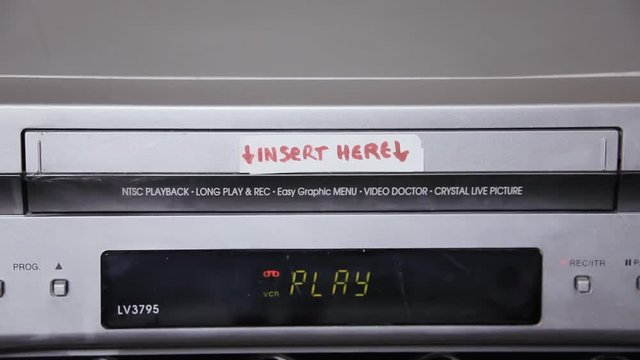 Inserting and removing a VHS tape from a VCR. The title says Our honeymoon.
