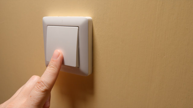 Human hand turn off a power button on a yellow wall - side view Stock Photo  | Adobe Stock