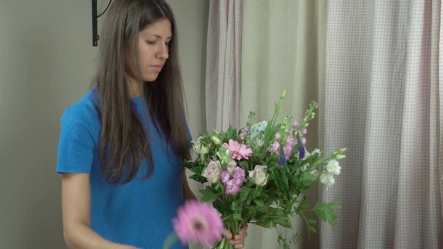 Attractive thirty-year-old woman florist makes a bouquet in a flower shop 4k.