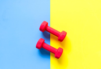 Fitness sports equipment top view, blue and yellow color background. Healthy Concept.