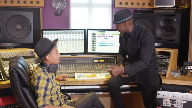  Music producer & sound engineer working together in recording studio