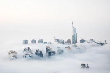 Rolgordijnen World's tallest skyscrapers surrounded by dense fog on a winter morning. Dubai, UAE. © Kertu