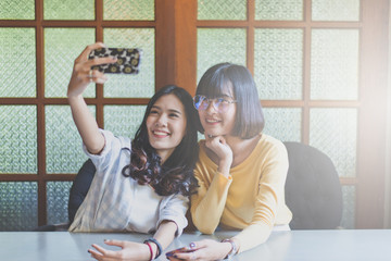 Portrait a beautiful asian teen woman smiling,happy,fun and selfie with her smartphone 