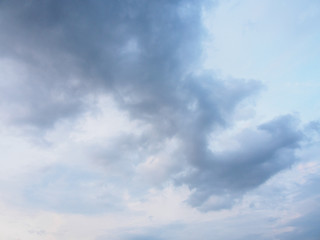 Wide angle view of sunny blue evening sky with dark, rainy, stratocumulus clouds. Cloudscapes and backgrounds concept.