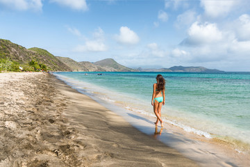 Fototapeta na wymiar Cruise tourist visiting St Kitts island on a Caribbean travel holiday. Bikini woman walking relaxing at South Frigate Bay beach in St Kitts.