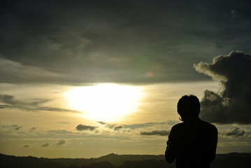 a man standing with sunset sky