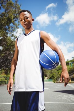 Portrait of male teenager holding ball