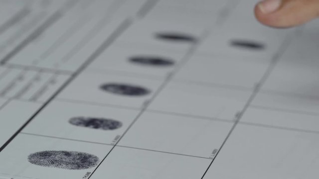 A man is being finger printed for either a crime  on a legal document form
