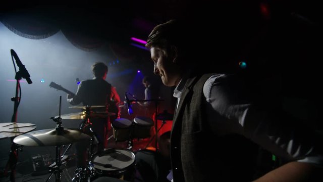  Drummer playing in a band at live music event