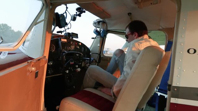 The pilot sits down in the cockpit.