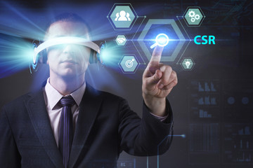 Business, Technology, Internet and network concept. Young businessman working in virtual reality glasses sees the inscription: CSR