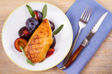 Duck breast with plums and sage. View from above, top studio shot, horizontal