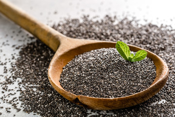 Dry healthy food - omega-3 source - macro of chia seed on wooden spoon