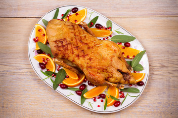 Whole duck with oranges, berries, sage and rosemary. View from above, top studio shot