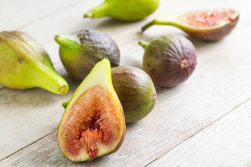 Fresh, juicy green figs on wooden table, one cut in half