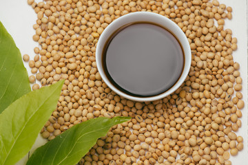 Soy sauce and soy bean on wooden table