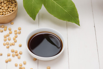 Soy sauce and soy bean on wooden table