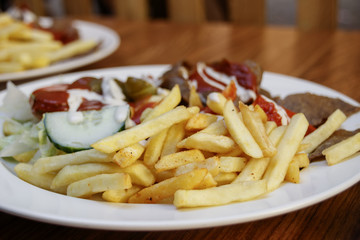Fried potatoes with meat and salad