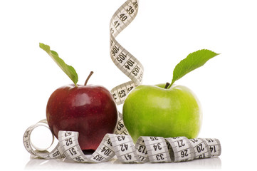 Green Apple and Red Apple with measuring tape on white background