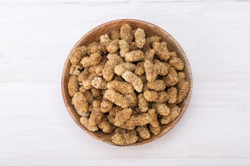 Top View Of Dried White Mulberries Fruits In A Wooden Bowl Isolated On White Wooden Background, A Healthy And Popular Sweet Snacks In Iran And Turkey