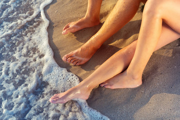 Obraz na płótnie Canvas Vacation holidays. Close up of male and females feet on the beach.