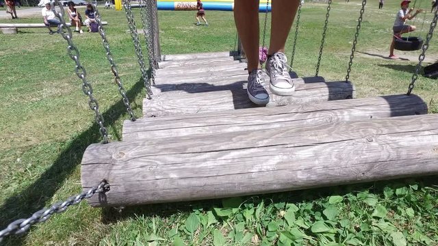 Girl passing on wooden Bridge on the playground