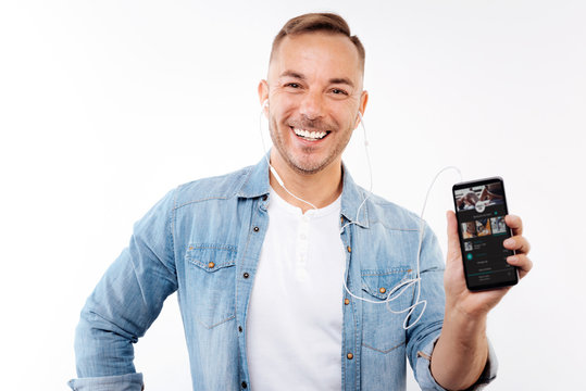 Cheerful man showing his favorite music app