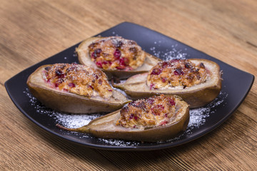 Homemade baked pears with cottage cheese, honey, red cranberries and walnuts, close up