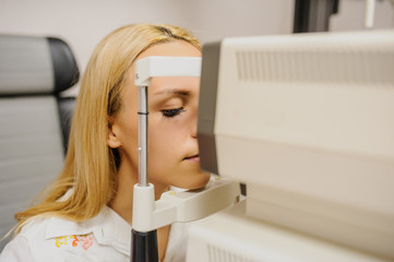 close up head of young patient fix in a non-mydriatic retinal camera