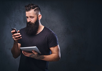 A man holds tablet PC and smartphone.