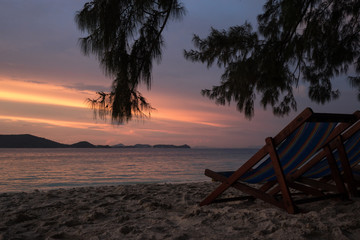 Beautiful views of the island of Ko HE in Thailand in the dawn and dusk hours. Sunbeds by the sea at sunset