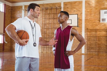 Coach guiding basketball player