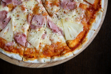 pizza hawaiian , pizza with pineapple and ham with cheese and tomatoes sauce on wood background , italian food