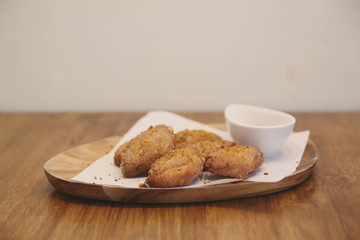 Fried chicken wings on wood background with restaurant light