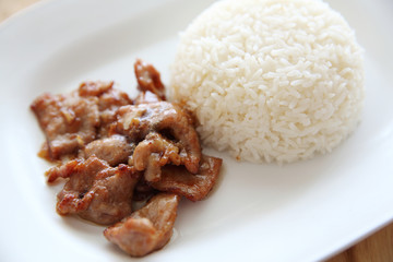 fried pork with garlic and rice on wood background , Thai food